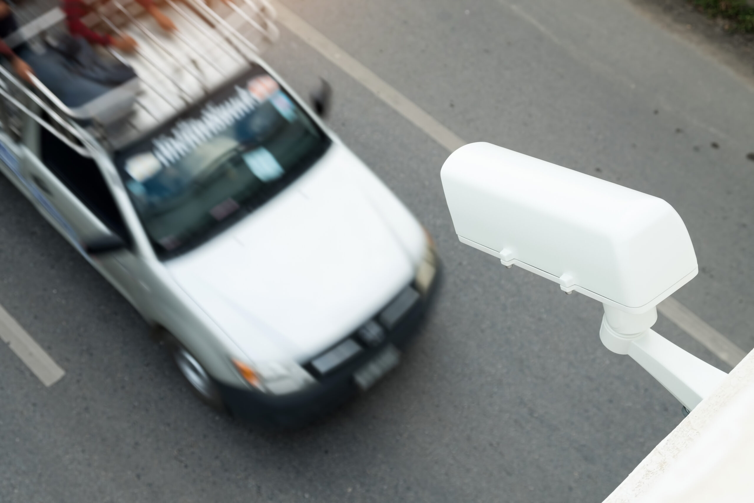 Professional ANPR camera installation for commercial traffic management, showing high-speed license plate recognition as cars pass through a business premises.