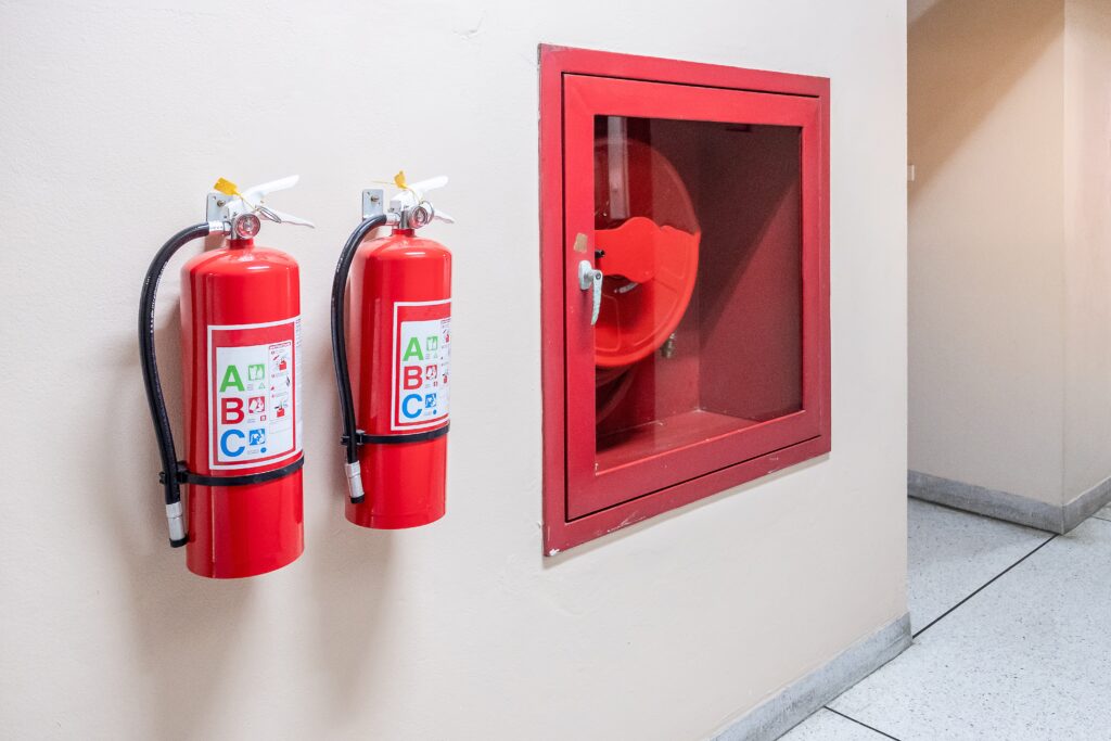 Essential fire safety equipment including a fire extinguisher installed alongside emergency lighting for building safety in Coventry.