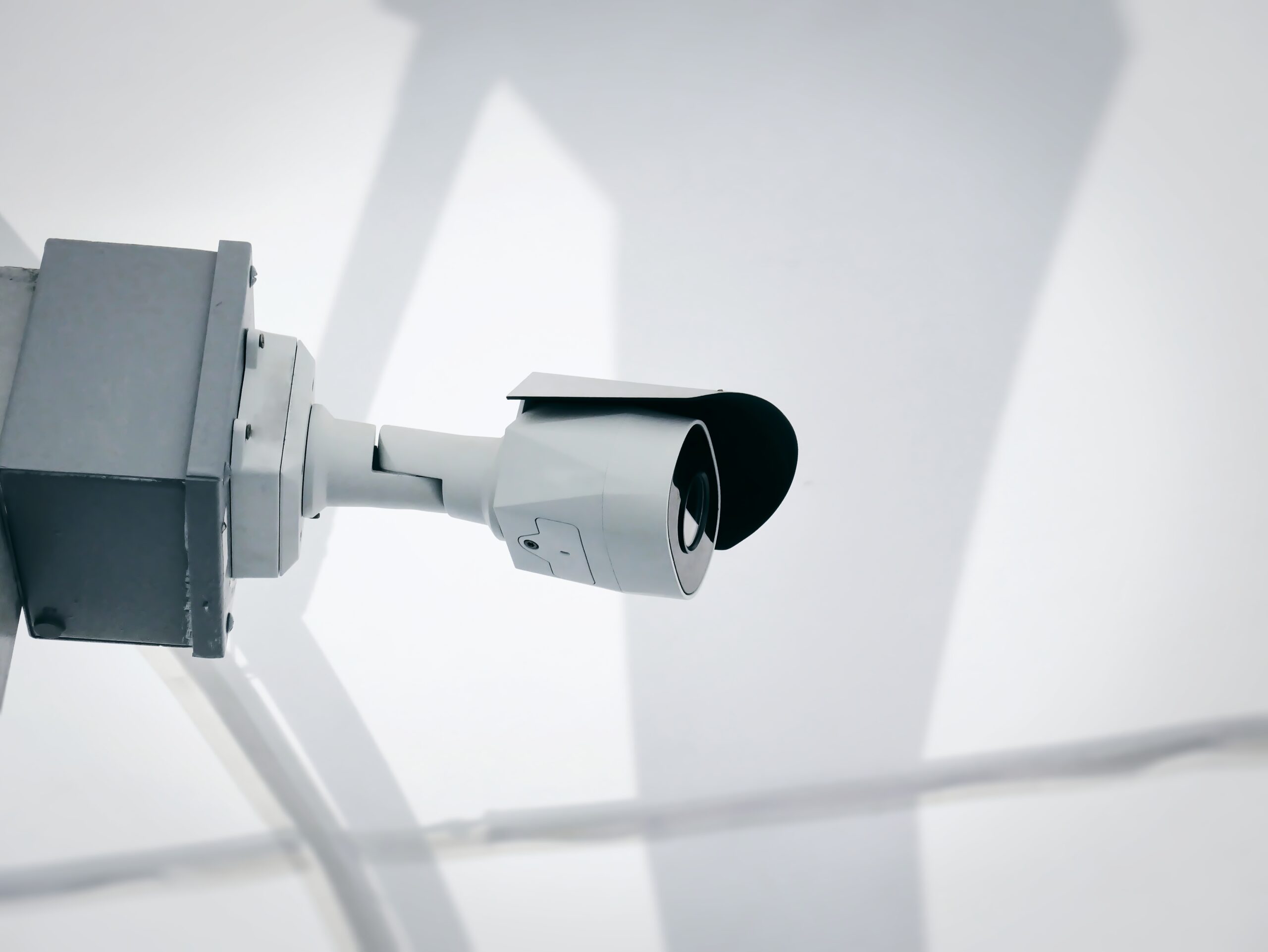 Exterior commercial security camera connected to a 24/7 remote monitoring control room for constant property surveillance.