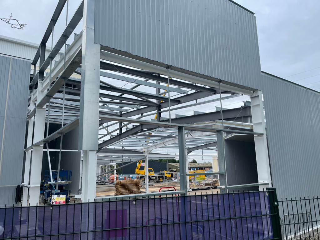 A secure metal bin store structure installed alongside a commercial building in Coventry, providing a durable waste management solution.