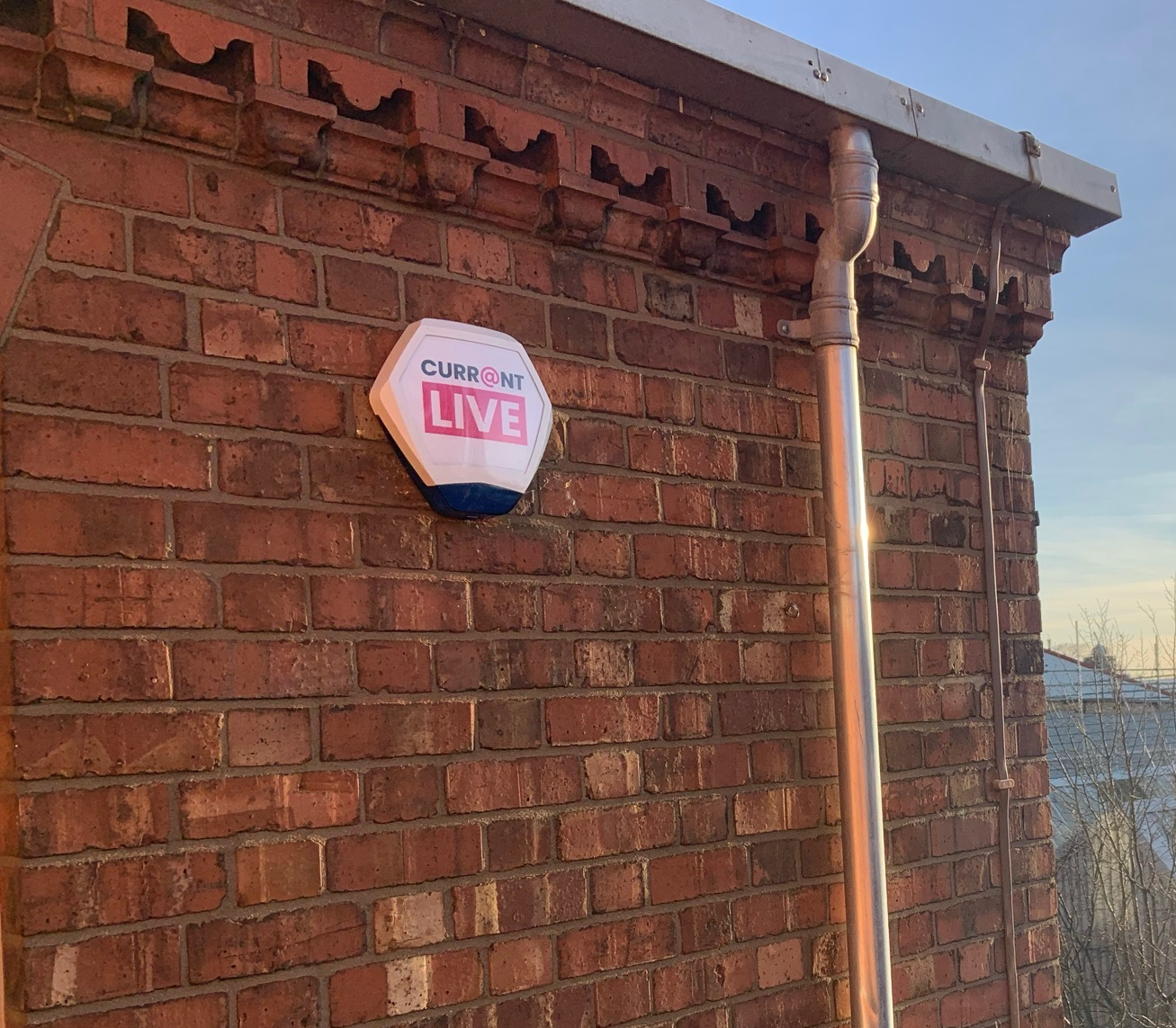 A high-visibility Currainlive intruder alarm box mounted on a commercial building to deter unauthorized access.